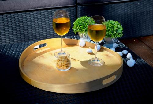 two glasses of wine sitting on a wooden table at Villa Dakota - jacuzzi, zwembad, playstation in Durbuy