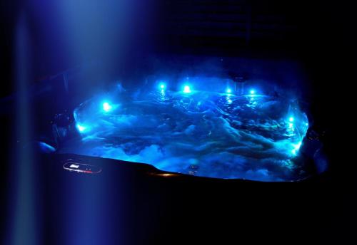 a stove with blue lights in a dark room at Villa Dakota - jacuzzi, zwembad, playstation in Durbuy