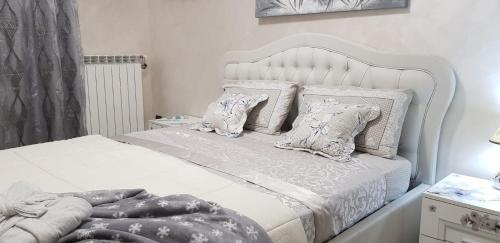 a bedroom with a white bed with pillows at Appartamento Malpensa Rho in Samarate