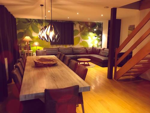 a living room with a wooden table and a couch at Villa Dakota - jacuzzi, zwembad, playstation in Durbuy