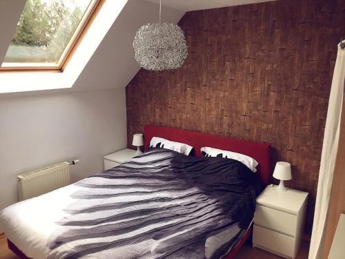 a bedroom with a large bed and a chandelier at Villa Dakota - jacuzzi, zwembad, playstation in Durbuy