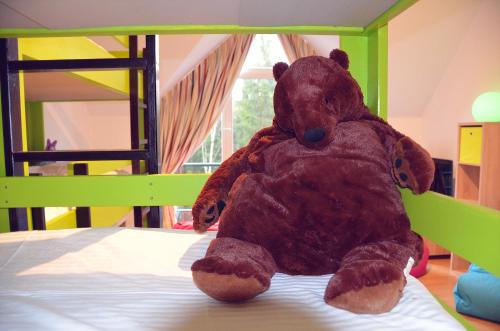a large brown teddy bear sitting on a bunk bed at Villa Dakota - jacuzzi, zwembad, playstation in Durbuy