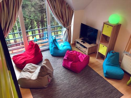 a living room with four bean bags and a television at Villa Dakota - jacuzzi, zwembad, playstation in Durbuy