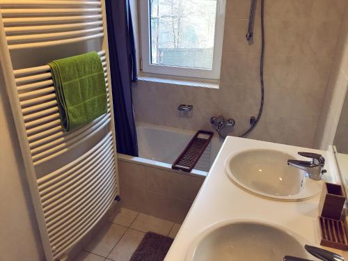 a bathroom with a sink and a toilet and a tub at Villa Dakota - jacuzzi, zwembad, playstation in Durbuy