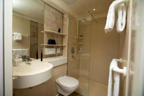 a bathroom with a sink and a toilet and a shower at ibis Berlin City Süd in Berlin