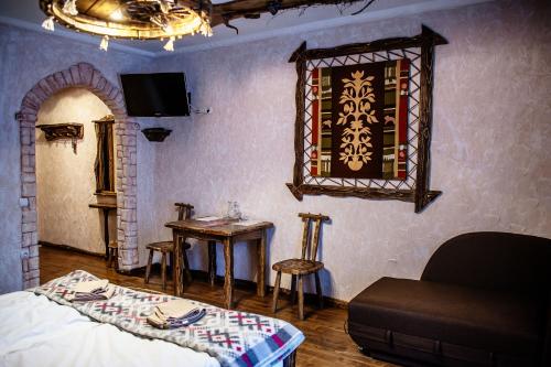 a bedroom with a bed and a table and a chair at SPA HOTEL Gora in Bukovel