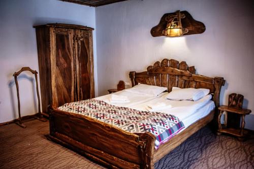 a bedroom with a bed with a wooden head board at SPA HOTEL Gora in Bukovel