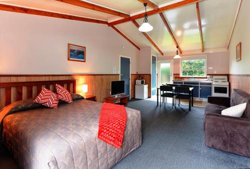 ein Schlafzimmer mit einem Bett und ein Wohnzimmer in der Unterkunft Fairy Springs Motel in Rotorua
