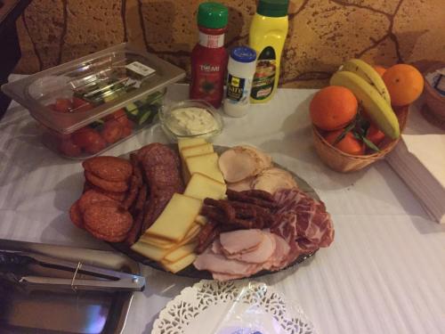 a table with a plate of cheese and other foods at Oli House in Alba Iulia
