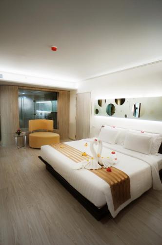 a bedroom with a large bed with flowers on it at Pattaya Discovery Beach Hotel in Pattaya