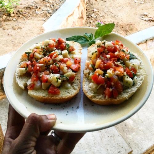 a person holding a plate with two pizzas on it at Deepsky Villa in Karimunjawa