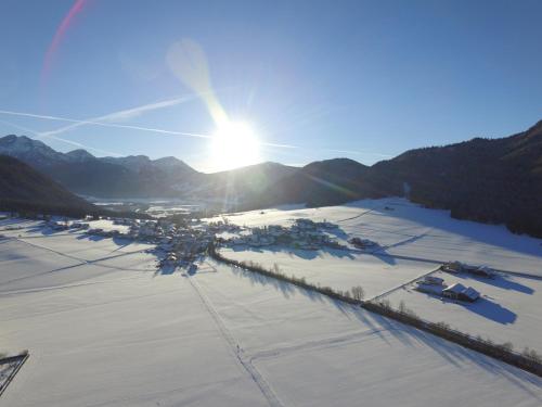 an aerial view of a town in the snow with the sun at Garni Renzler in Rasun di Sopra