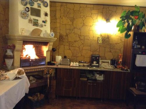 a kitchen with a fireplace and a counter with a table at Oli House in Alba Iulia