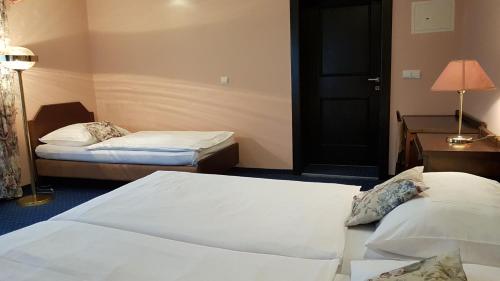 a hotel room with two beds and a door at Eurohotel in Karlovy Vary