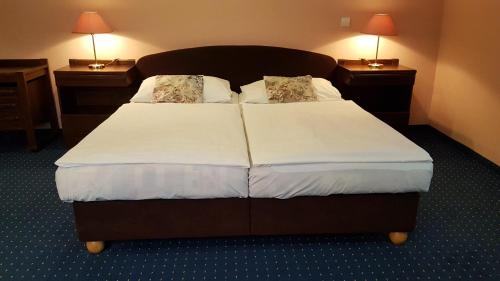 a hotel room with a large bed with two night stands at Eurohotel in Karlovy Vary