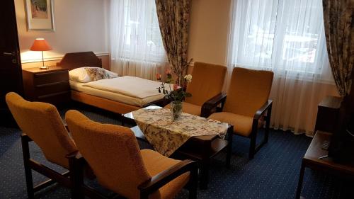 a hotel room with a bed and a table and chairs at Eurohotel in Karlovy Vary