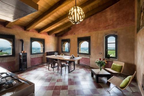 ein Esszimmer mit einem Tisch, Stühlen und Fenstern in der Unterkunft Palazzo d'Assi - Guest house in Monforte dʼAlba