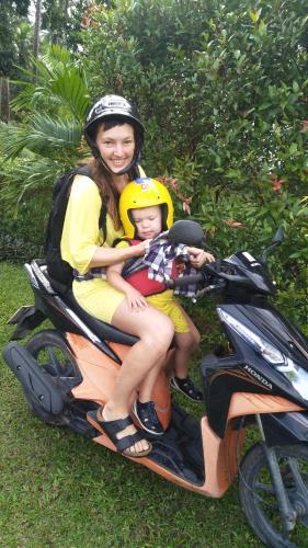 a woman and a child riding a scooter at Sean Sabai Home e Ristobar in Taling Ngam Beach
