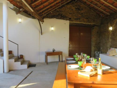 a dining room with a wooden table with wine glasses at casAlice country house in Alvoeira