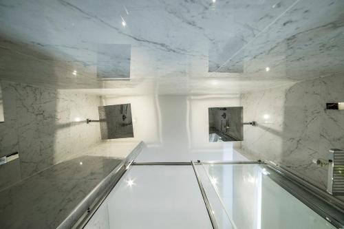 a white marble bathroom with a glass floor at Rocca Palazzaccio in Impruneta
