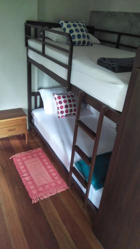 two bunk beds in a room with a red rug at Sean Sabai Home e Ristobar in Taling Ngam Beach