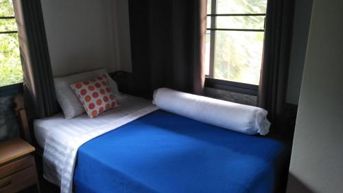 a bedroom with a bed with a pillow and a window at Sean Sabai Home e Ristobar in Taling Ngam Beach