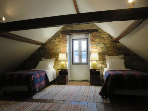 a attic room with two beds and two windows at casAlice country house in Alvoeira