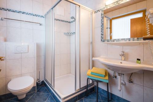 a bathroom with a shower and a sink and a toilet at Frühstückspension Rötelstein in Ramsau am Dachstein