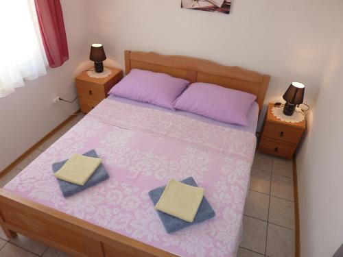 ein kleines Schlafzimmer mit einem rosa Bett mit zwei Nachttischen in der Unterkunft Queen beach Apartments - private pool - Sabunike III in Privlaka