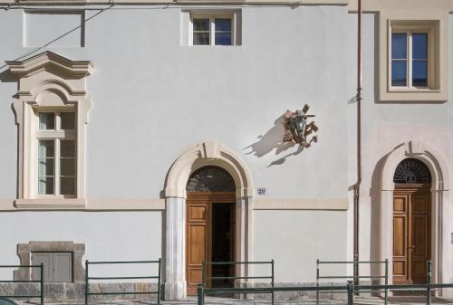 a building with two doors and a statue of a bird at QUADRATO in Turin