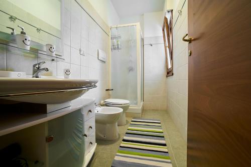uma casa de banho com um lavatório e um WC em Arcibaleno em Sabaudia