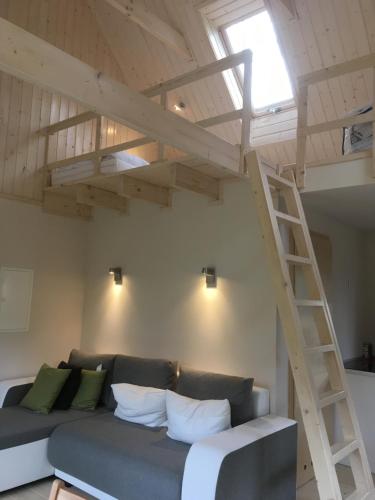 a loft room with a couch and a ladder at Ferienhof Ohlenbusch in Worpswede