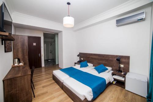 a bedroom with a large bed with blue pillows at Tbilisi View Hotel in Tbilisi City
