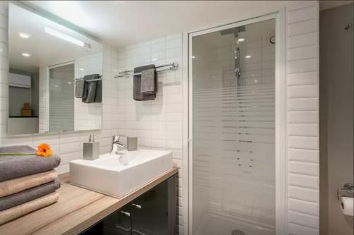 une salle de bain blanche avec un lavabo et une douche dans l'établissement Loft St. Germain, à Paris