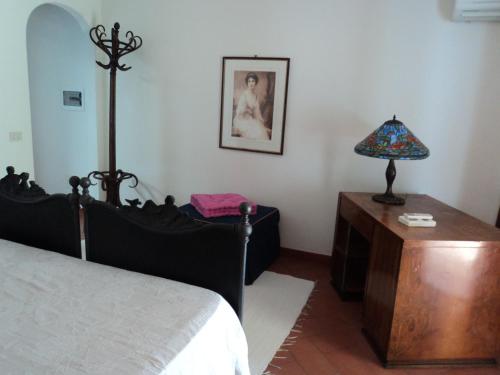 a bedroom with a bed and a table with a lamp at Villa Valle Canale in Marina