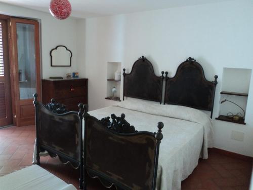 a bedroom with a large bed and two chairs at Villa Valle Canale in Marina