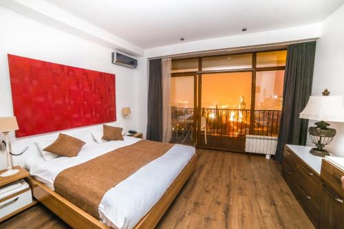 a bedroom with a large bed and a large window at Tbilisi View Hotel in Tbilisi City