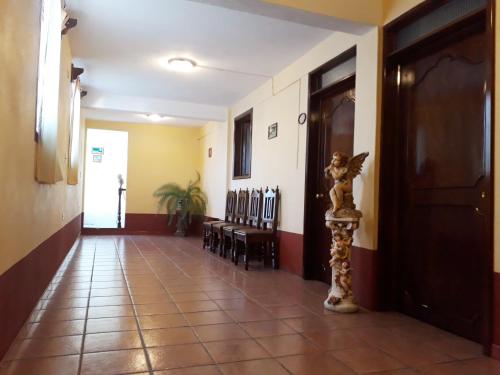 a hallway with chairs and a door and a cat statue at Hotel Camino de Villaseca in Guanajuato