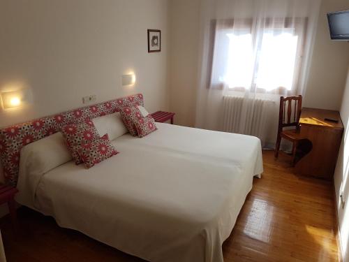 1 dormitorio con cama blanca y ventana en Quinto Real Turismo Rural, en Eugi