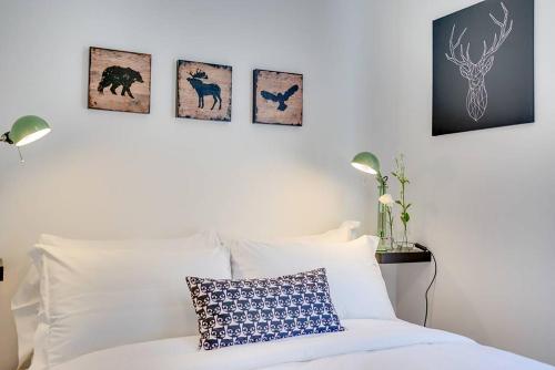 una camera da letto con un letto bianco con quattro immagini sul muro di San Lorenzo Home a Roma
