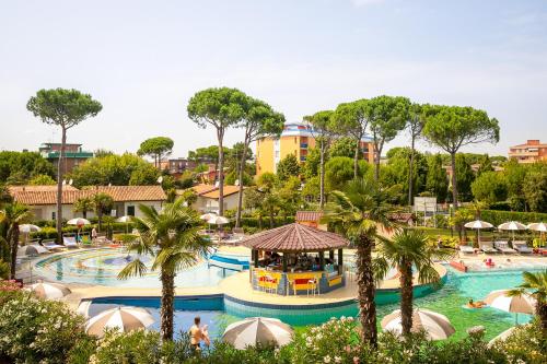 uma piscina num resort com palmeiras em Mediterranee Family & Spa Hotel em Bibione