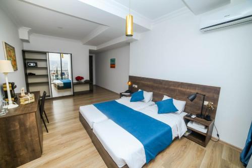 a bedroom with a large bed with blue pillows at Tbilisi View Hotel in Tbilisi City