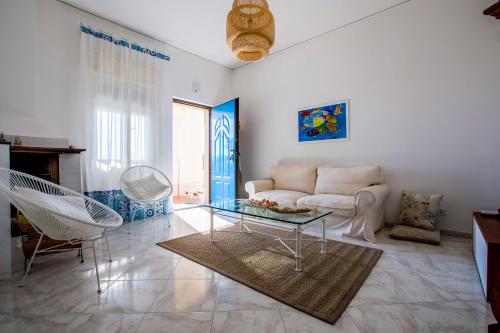 uma sala de estar com um sofá e uma mesa de vidro em Villa Ammari em Avola