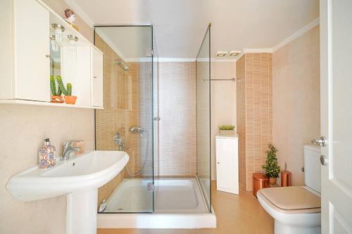 a bathroom with a shower and a sink and a toilet at Lina's Sea View Apartments in Limenas