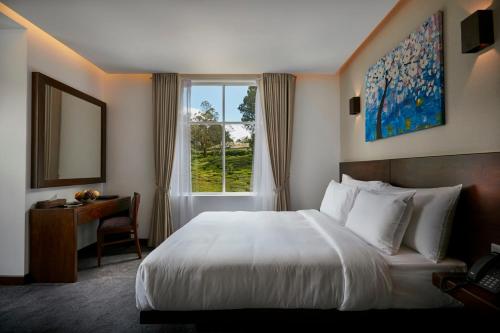 um quarto de hotel com uma cama e uma janela em Galway Heights Hotel em Nuwara Eliya