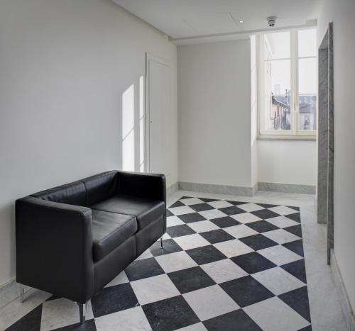 a black leather couch in a room with a checkered floor at QUADRATO in Turin