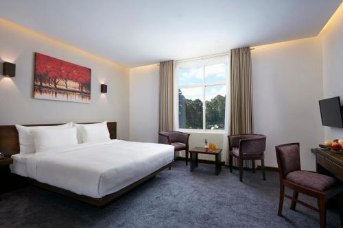 a hotel room with a bed and a desk at Galway Heights Hotel in Nuwara Eliya