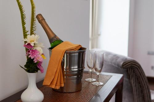 a bottle of wine in a bucket on a table with glasses at Galway Heights Hotel in Nuwara Eliya