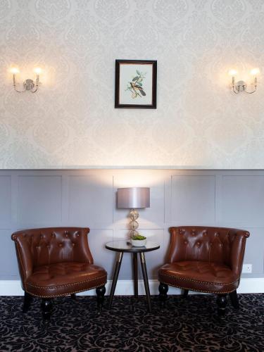 two leather chairs and a table in a room at Elfordleigh Hotel in Plymouth