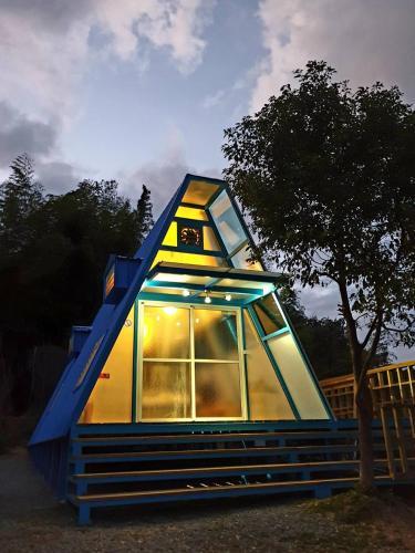 a tiny house with a blue roof and windows at 深山林內民宿 in Zhushan